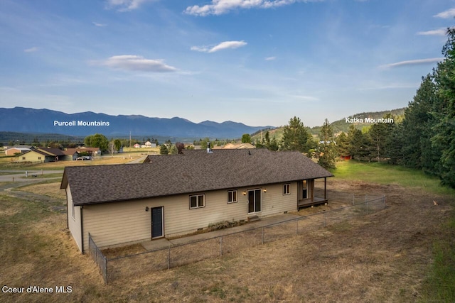 156 Promise Ln, Moyie Springs, ID 83845 - rear view of house with a mountain view, a fenced backyard, and roof with shingles