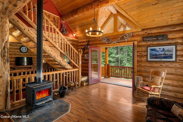 26443 S Farup Rd, Worley, ID 83876 - unfurnished living room featuring log walls, a wooden ceiling with exposed beams, a wood stove, wood finished floors, and stairs