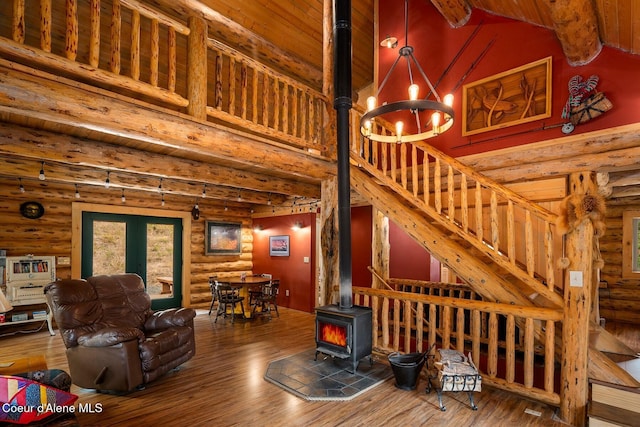 26443 S Farup Rd, Worley, ID 83876 - living area featuring a wood stove, log walls, wood finished floors, stairs, and a chandelier