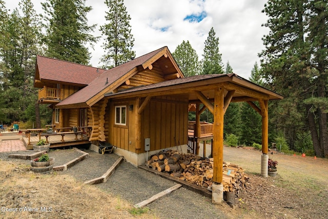 26443 S Farup Rd, Worley, ID 83876 - view of front of home with a deck, log siding, board and batten siding, and a shingled roof