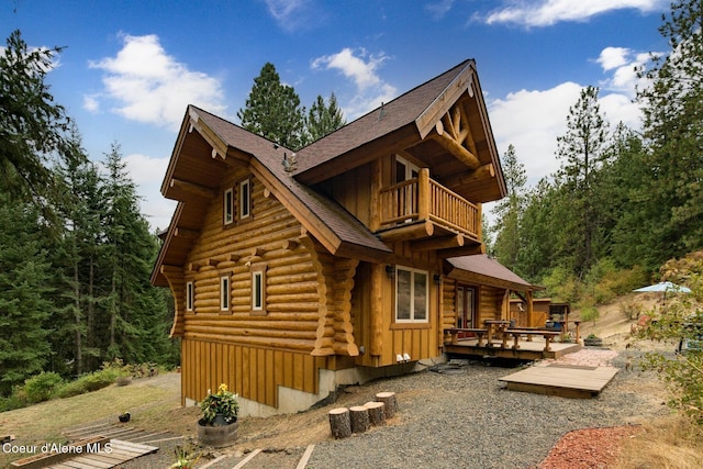 26443 S Farup Rd, Worley, ID 83876 - rear view of house featuring a balcony, log exterior, a wooden deck, and roof with shingles