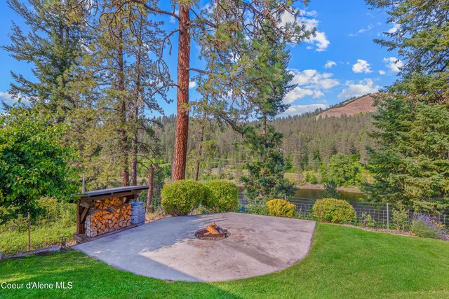 822 Ridgewood, Kamiah, ID 83536 - view of green lawn with a view of trees, a fire pit, and a patio area
