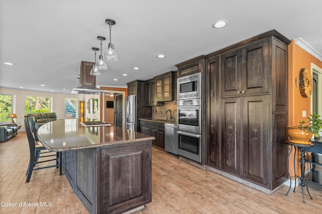 822 Ridgewood, Kamiah, ID 83536 - kitchen featuring appliances with stainless steel finishes, a breakfast bar area, a center island, recessed lighting, and dark brown cabinetry