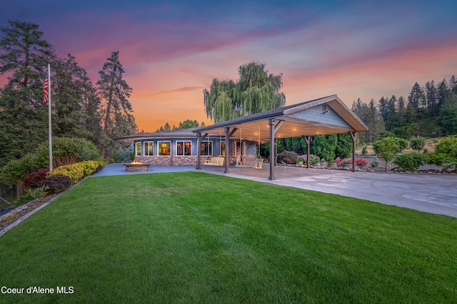 822 Ridgewood, Kamiah, ID 83536 - back of house at dusk with a yard, a patio, and a carport