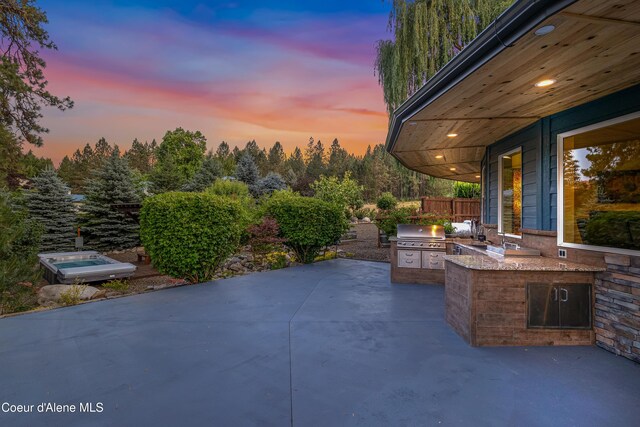 822 Ridgewood, Kamiah, ID 83536 - patio terrace at dusk with an outdoor kitchen and a patio area