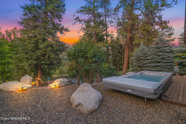822 Ridgewood, Kamiah, ID 83536 - yard at dusk featuring a hot tub and a deck