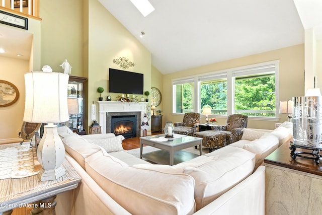 30 Beacon Hill Rd, Cocolalla, ID 83813 - living area featuring high vaulted ceiling, a lit fireplace, wood finished floors, and a skylight