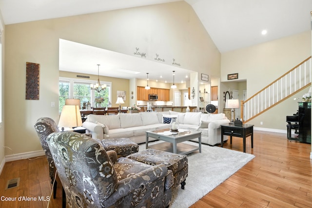 30 Beacon Hill Rd, Cocolalla, ID 83813 - living area featuring high vaulted ceiling, light wood-type flooring, a chandelier, and stairs