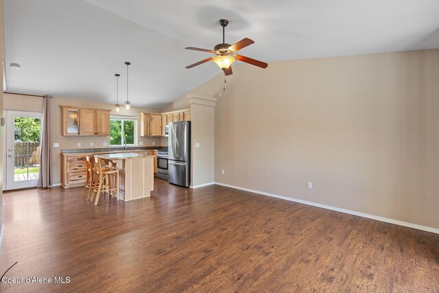 14106 N Lauren Loop, Rathdrum, ID 83858 - kitchen with stainless steel appliances, a kitchen island, a ceiling fan, a breakfast bar, and dark wood-style flooring