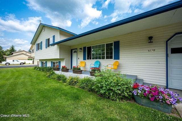 9270 N Maple St, Hayden, ID 83835 - view of front facade featuring covered porch, a front lawn, and a garage