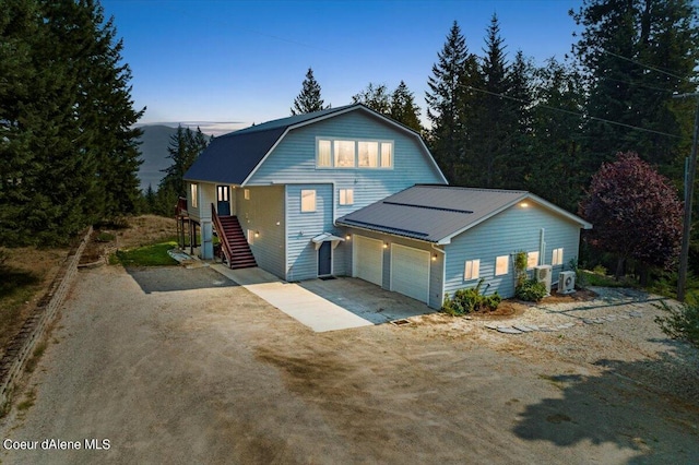 6101 Bottle Bay Rd, Sagle, ID 83860 - dutch colonial featuring a gambrel roof, concrete driveway, stairs, a garage, and a metal roof