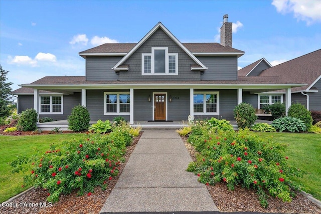 6744 E Greta Ave, Post Falls, ID 83854 - view of front of property with a chimney, covered porch, a front yard, and roof with shingles