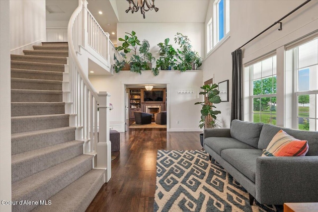 6744 E Greta Ave, Post Falls, ID 83854 - living area featuring a high ceiling, stairway, wood finished floors, a fireplace, and a chandelier