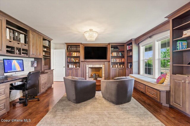 6744 E Greta Ave, Post Falls, ID 83854 - office area featuring built in study area, dark wood-style floors, a fireplace, and a chandelier