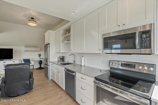 6744 E Greta Ave, Post Falls, ID 83854 - kitchen with stainless steel appliances, open shelves, a wall unit AC, and white cabinets