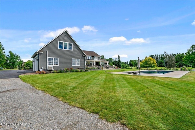 6744 E Greta Ave, Post Falls, ID 83854 - back of house featuring a yard, a garage, asphalt driveway, and cooling unit