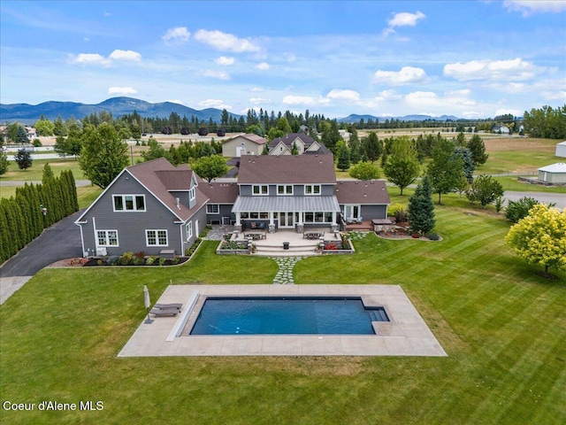 6744 E Greta Ave, Post Falls, ID 83854 - rear view of house featuring a mountain view, a yard, a patio, and an outdoor pool