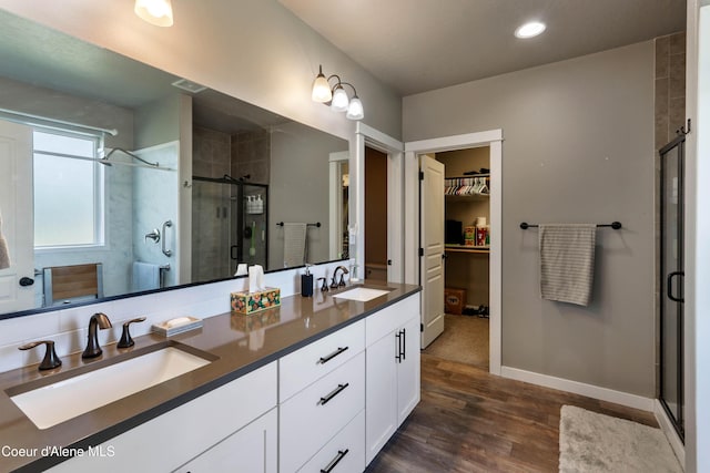 4574 N Connery Loop, Post Falls, ID 83854 - bathroom with a shower stall, double vanity, a spacious closet, wood finished floors, and recessed lighting