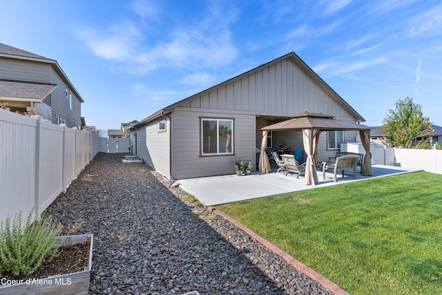 4574 N Connery Loop, Post Falls, ID 83854 - back of house with board and batten siding, a fenced backyard, and a patio area