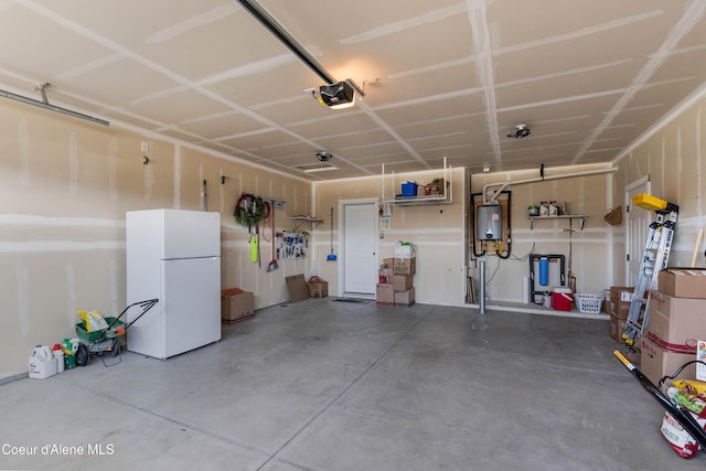 4574 N Connery Loop, Post Falls, ID 83854 - garage with freestanding refrigerator, a garage door opener, and water heater