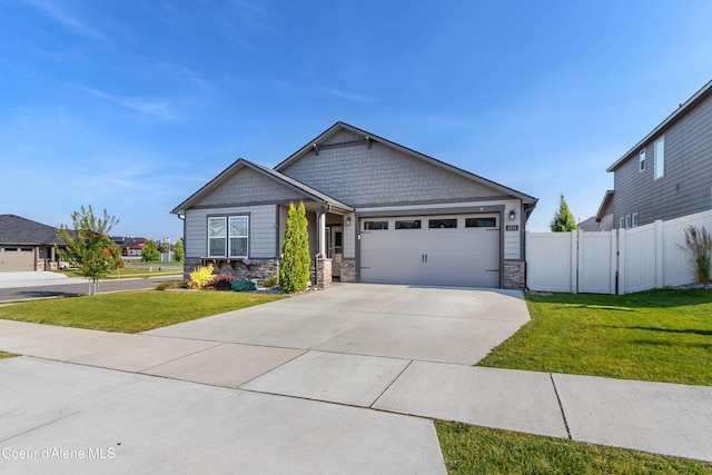 4574 N Connery Loop, Post Falls, ID 83854 - craftsman-style house with stone siding, an attached garage, and driveway