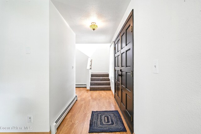 5678 N Pinegrove Dr, Coeur Dalene, ID 83815 - hallway with a baseboard heating unit, baseboard heating, stairway, and light wood-style flooring