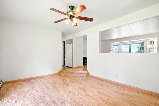 5678 N Pinegrove Dr, Coeur Dalene, ID 83815 - unfurnished room featuring wood finished floors, ceiling fan, and a baseboard heating unit