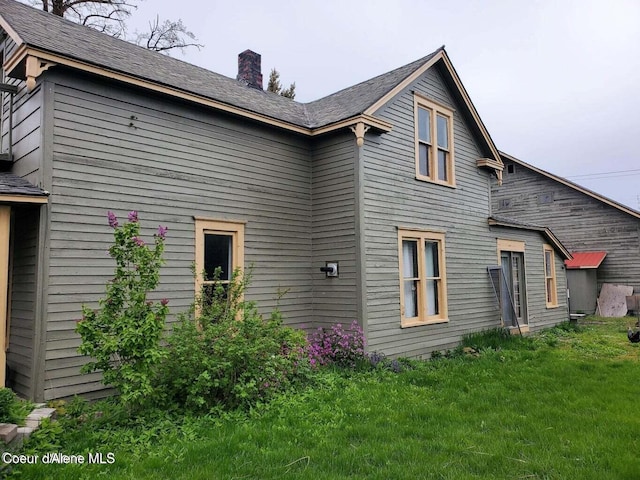 503 E 3rd Ave, Post Falls, ID 83854 - view of home's exterior with a chimney and a yard