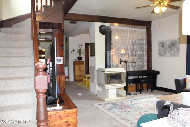 503 E 3rd Ave, Post Falls, ID 83854 - carpeted living area with a wood stove, ceiling fan, and stairway