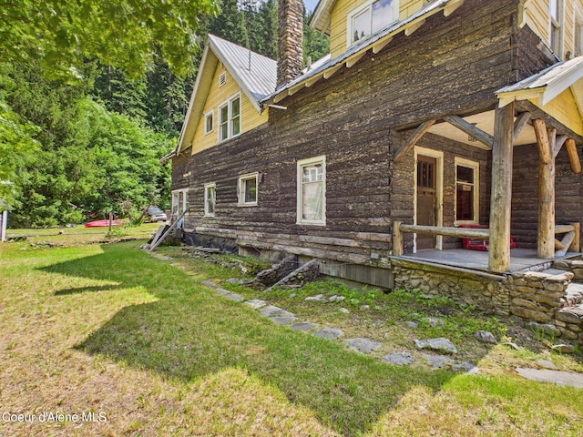 185 King St, Wallace, ID 83873 - view of side of property featuring a chimney, a lawn, and a metal roof