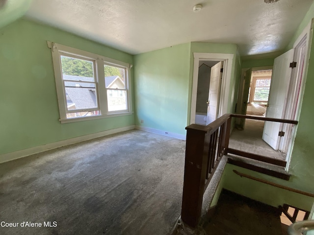 185 King St, Wallace, ID 83873 - unfurnished bedroom featuring carpet floors, multiple windows, and a textured ceiling