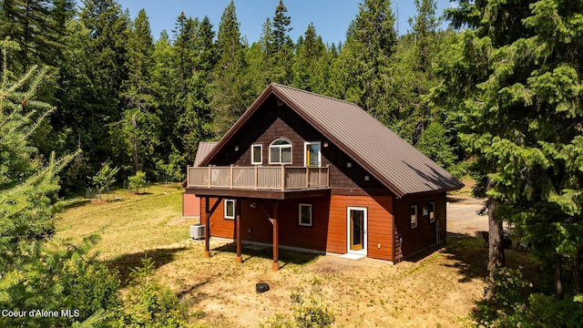 1911 Carr Creek Rd, Sandpoint, ID 83864 - view of front of house with a standing seam roof, a metal roof, a deck, and a view of trees