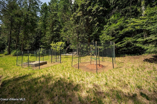 1911 Carr Creek Rd, Sandpoint, ID 83864 - view of green lawn featuring a vegetable garden and a wooded view