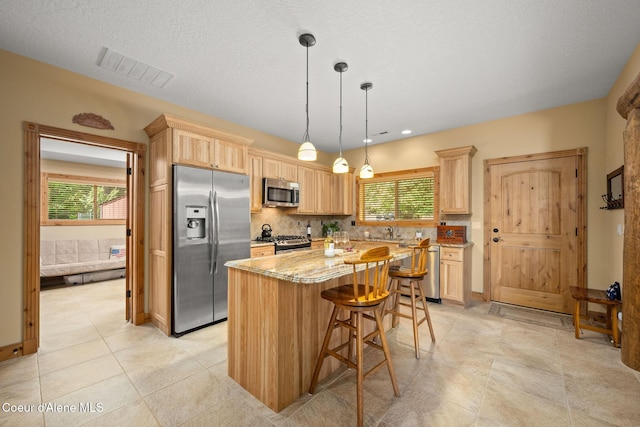 1911 Carr Creek Rd, Sandpoint, ID 83864 - kitchen featuring stainless steel appliances, light brown cabinets, a kitchen island, plenty of natural light, and recessed lighting