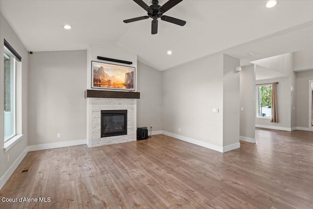 1877 W Orchard Ave, Hayden, ID 83835 - unfurnished living room featuring a stone fireplace, wood finished floors, lofted ceiling, ceiling fan, and recessed lighting