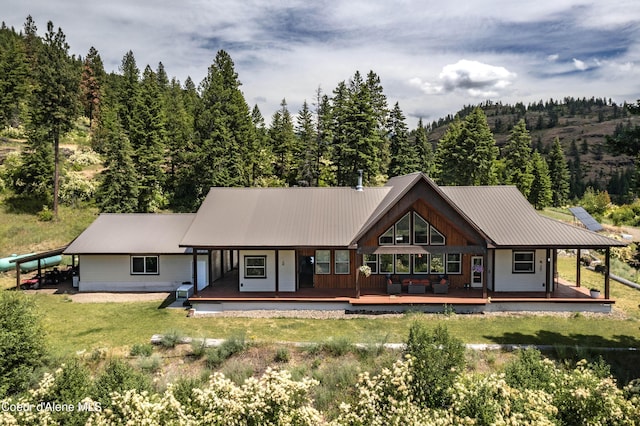 1010 Mc Quade Gulch Dr, Clark Fork, ID 83811 - back of house featuring a yard, a view of trees, a metal roof, and a porch