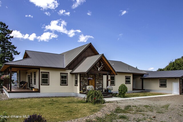 1010 Mc Quade Gulch Dr, Clark Fork, ID 83811 - view of front of house with a porch, a front yard, a metal roof, and stone siding