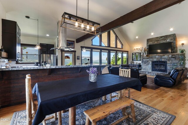 1010 Mc Quade Gulch Dr, Clark Fork, ID 83811 - dining space featuring beam ceiling, wood finished floors, a fireplace, recessed lighting, and high vaulted ceiling