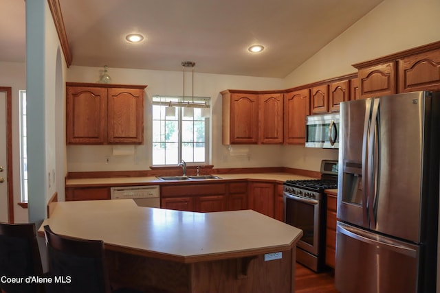 1276 W Edgewood Cir, Coeur Dalene, ID 83815 - kitchen featuring stainless steel appliances, brown cabinets, vaulted ceiling, light countertops, and a kitchen island