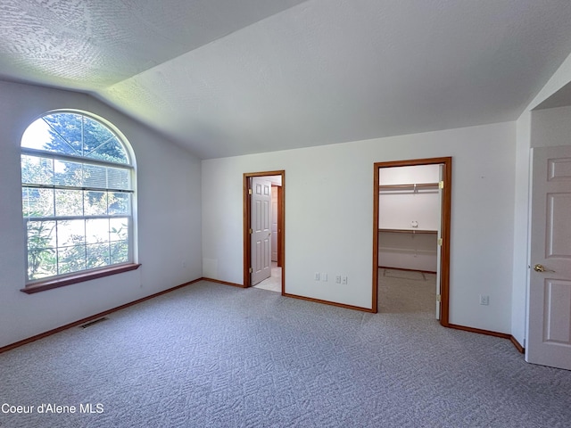 1276 W Edgewood Cir, Coeur Dalene, ID 83815 - unfurnished bedroom with vaulted ceiling, carpet, and a spacious closet