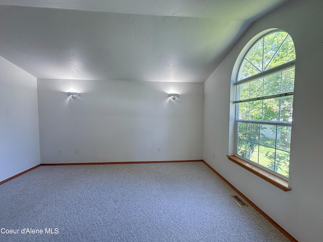 1276 W Edgewood Cir, Coeur Dalene, ID 83815 - unfurnished room with vaulted ceiling, healthy amount of natural light, and light colored carpet