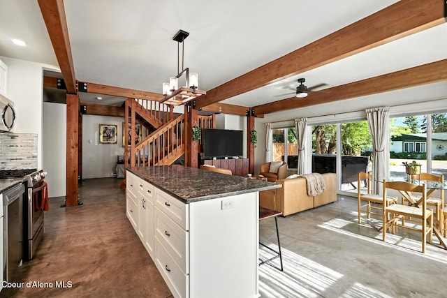 1106 Larch St Unit A, Sandpoint, ID 83864 - kitchen featuring appliances with stainless steel finishes, a kitchen bar, concrete flooring, beam ceiling, and ceiling fan
