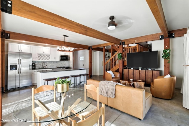 1106 Larch St Unit A, Sandpoint, ID 83864 - living room featuring beamed ceiling, concrete floors, a ceiling fan, and stairs