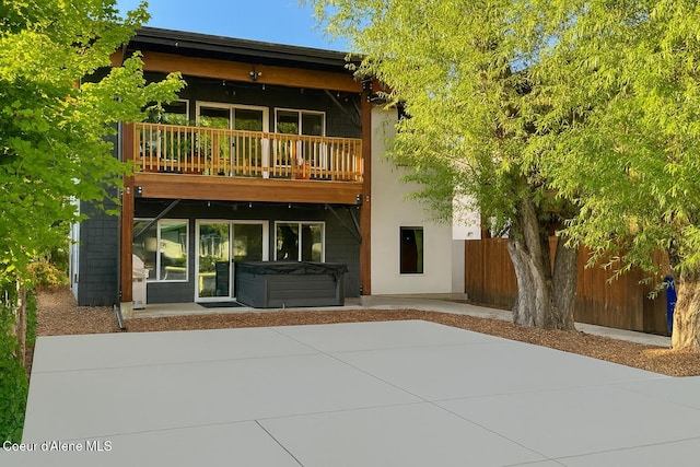 1106 Larch St Unit A, Sandpoint, ID 83864 - rear view of property with a hot tub, a patio area, a balcony, and stucco siding