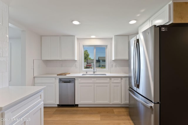 15116 E 4th Ave, Veradale, WA 99037 - kitchen featuring stainless steel appliances, light wood-style flooring, white cabinetry, light countertops, and backsplash