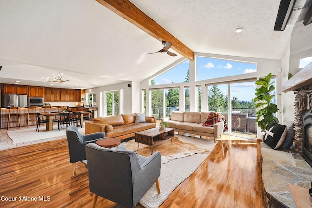 1273 S Grouse Meadow Dr, Coeur Dalene, ID 83814 - living room with light wood finished floors, a textured ceiling, a stone fireplace, and a chandelier