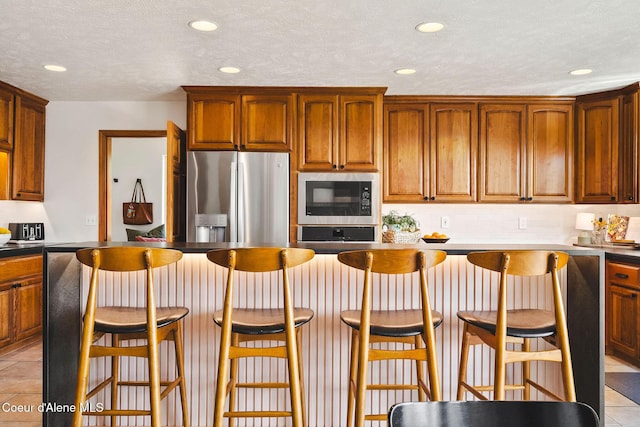 1273 S Grouse Meadow Dr, Coeur Dalene, ID 83814 - kitchen with built in microwave, stainless steel fridge with ice dispenser, recessed lighting, tasteful backsplash, and light tile patterned floors