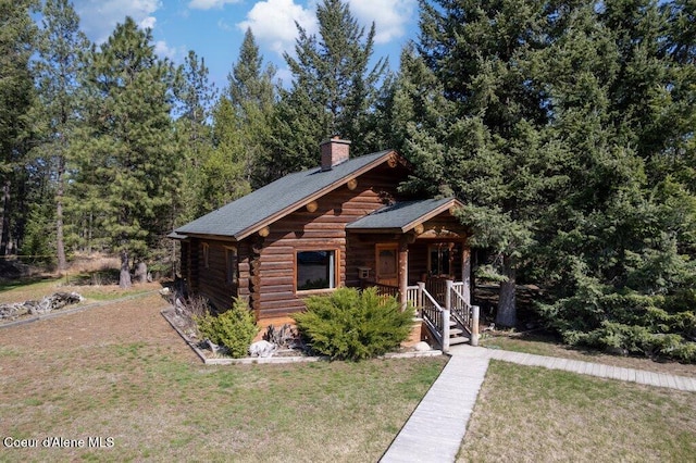 72 Hank Allen Way, Blanchard, ID 83804 - log cabin with covered porch, a chimney, a front lawn, and log siding