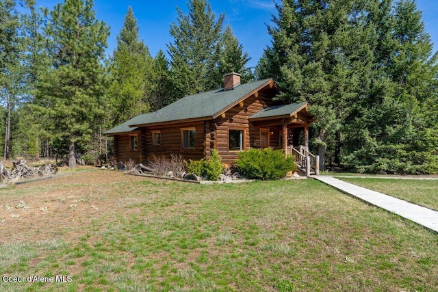 72 Hank Allen Way, Blanchard, ID 83804 - view of front facade with log siding, a front yard, a porch, and a chimney