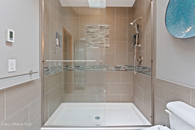 3011 E Fernan Ct, Coeur Dalene, ID 83814 - bathroom featuring a shower stall, tile walls, and a wainscoted wall